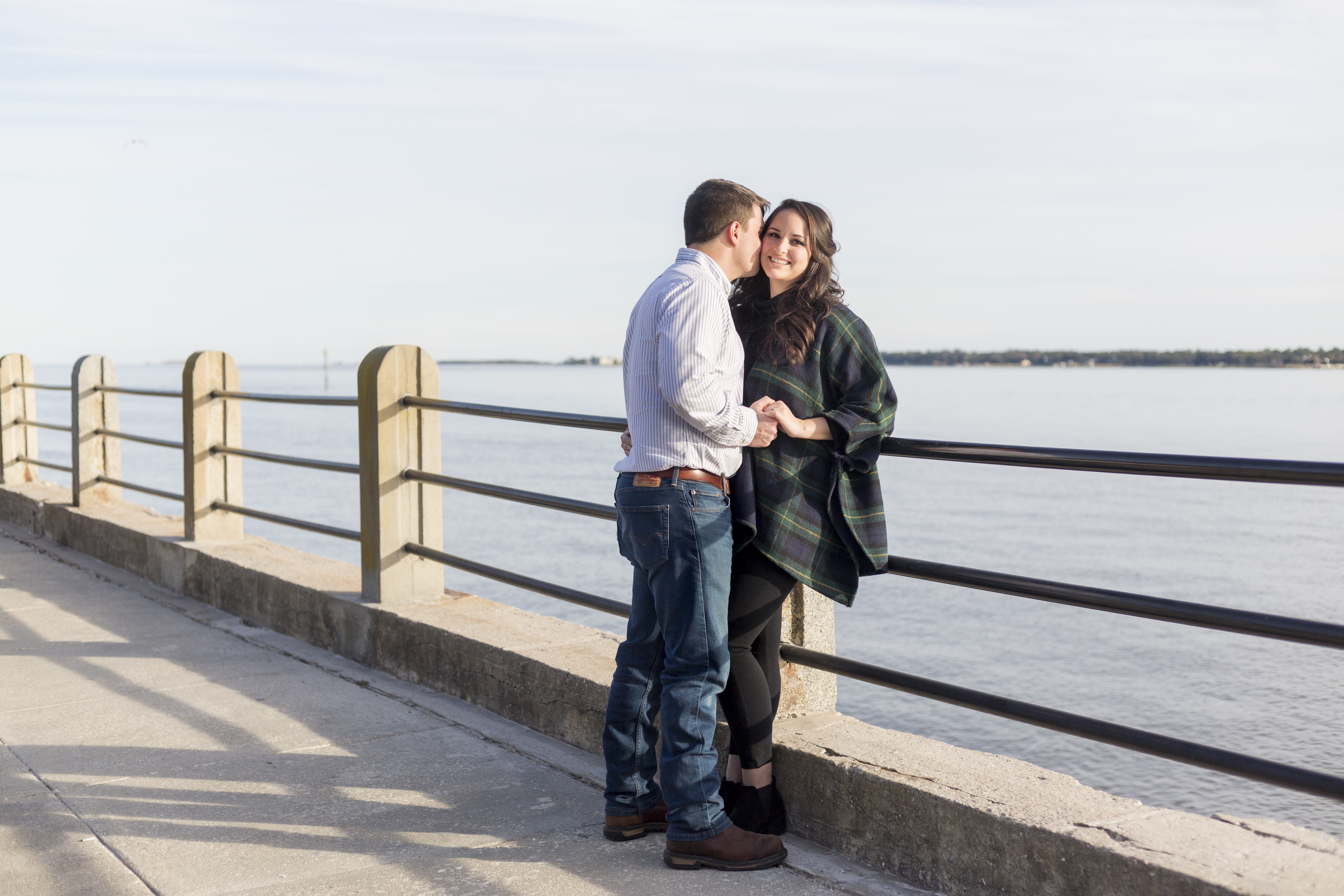 The couple is standing at the waterfront.