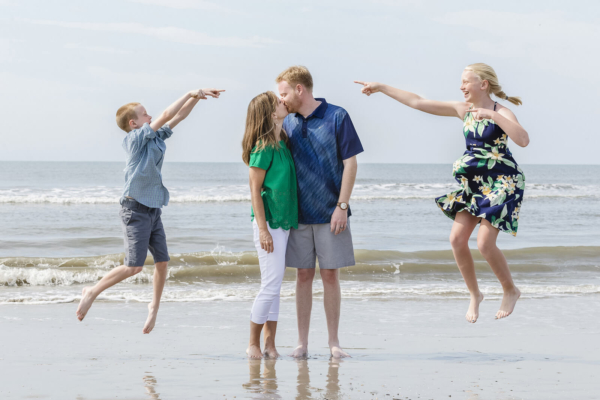family photo charleston kids are jumping near their parents on the beach