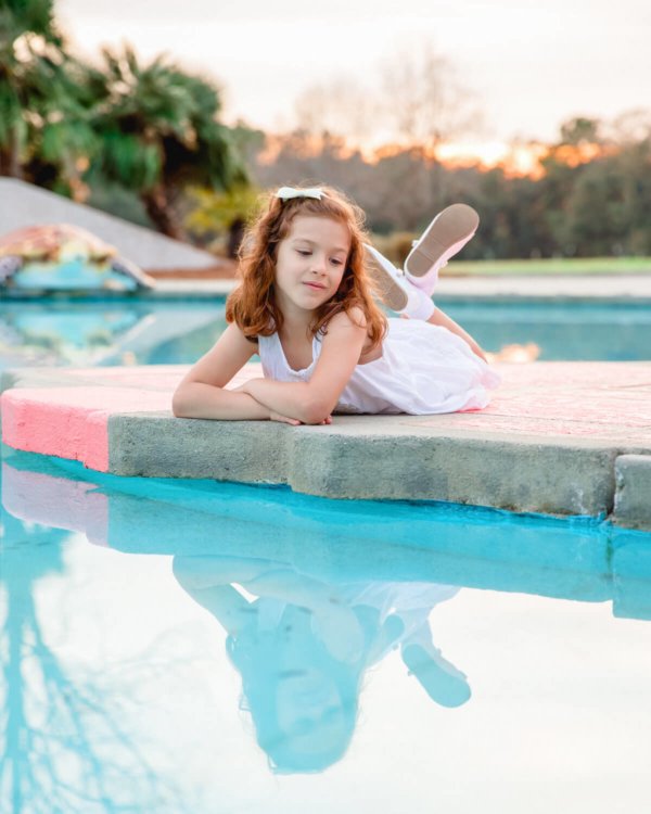 family photo charleston girl’s reflection is seen in swimming pool