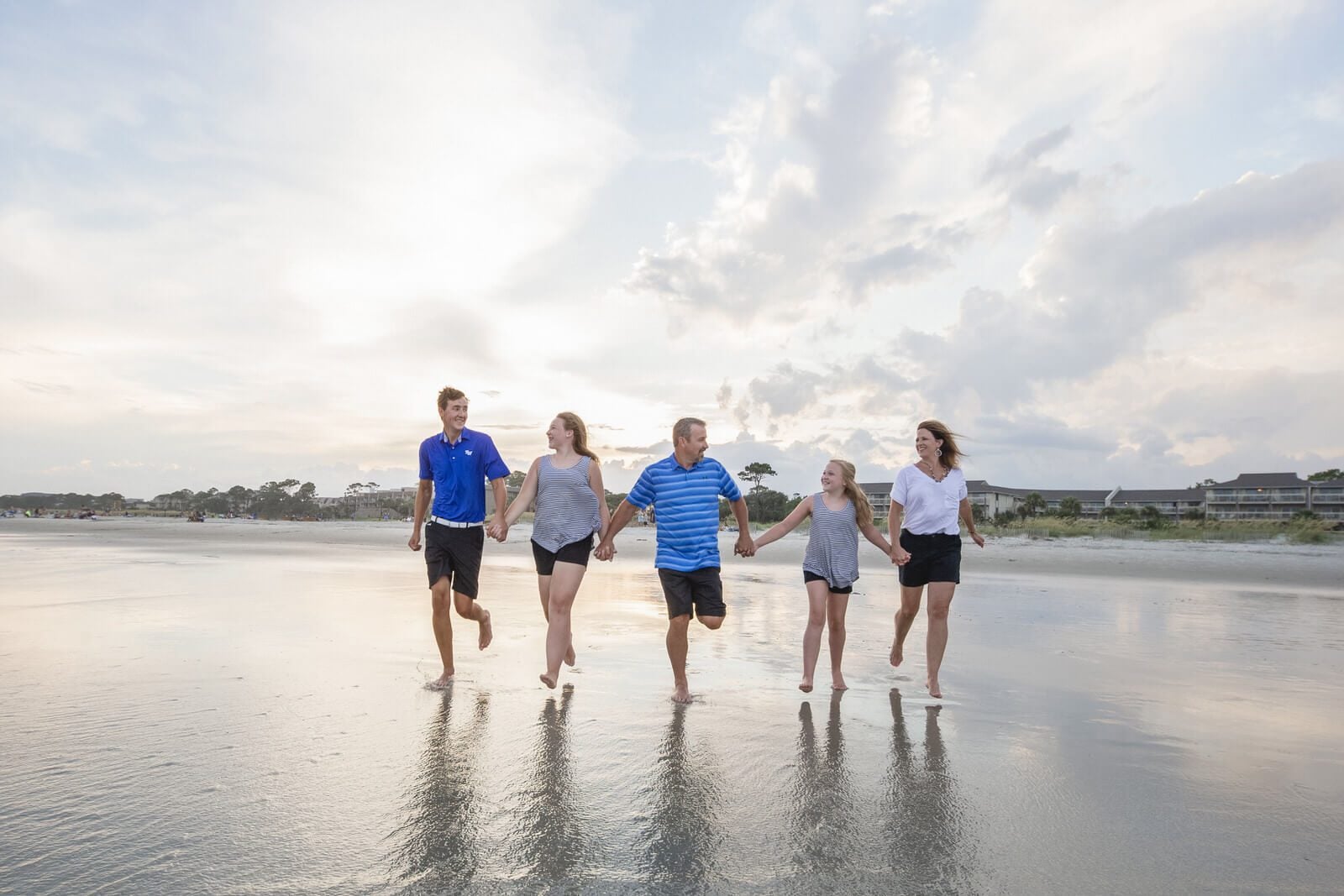 family photo charleston the whole family is running on the beach on the background of the sky