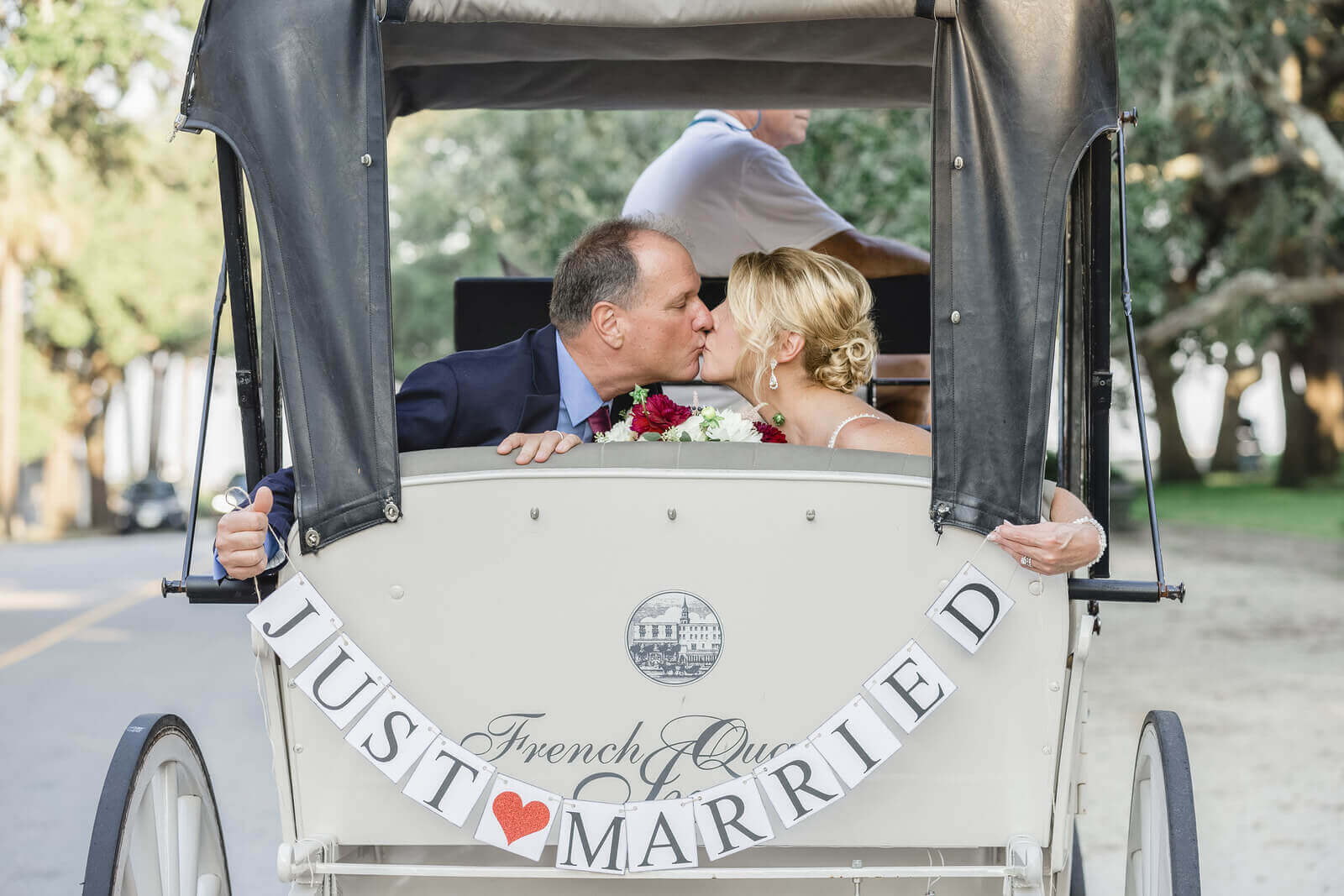 bride and groom ride in a carriage and hold the inscription just married 