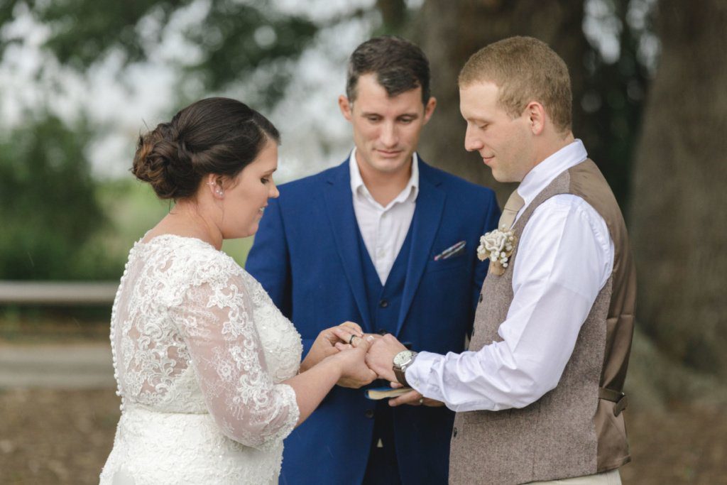 she is pulling the ring on his finger