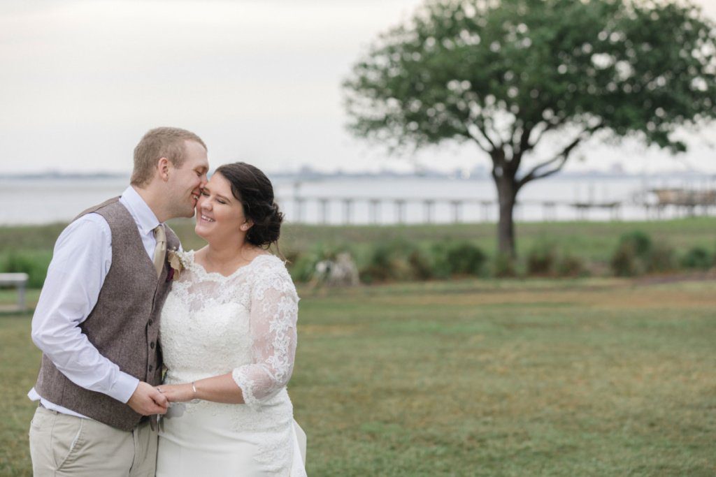 bride and groom hugging on the background of a tree