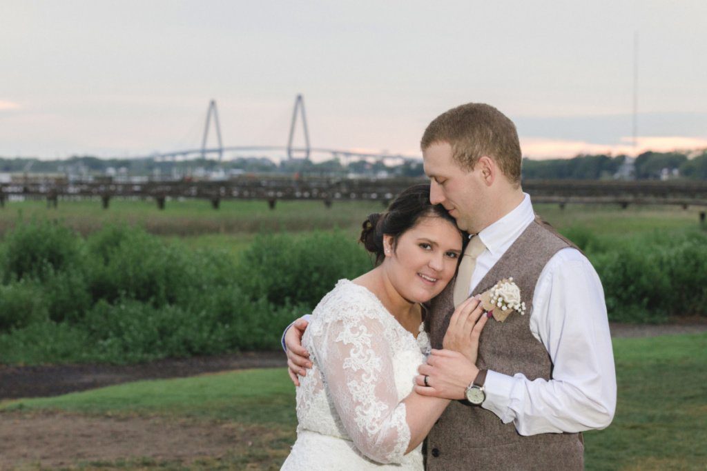 bride and groom hugging on the background of greenery