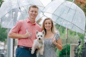 a couple under an umbrella with a dog