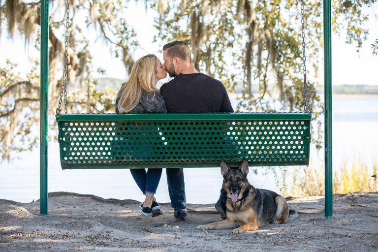 a loving couple on a swing and their beautiful dog
