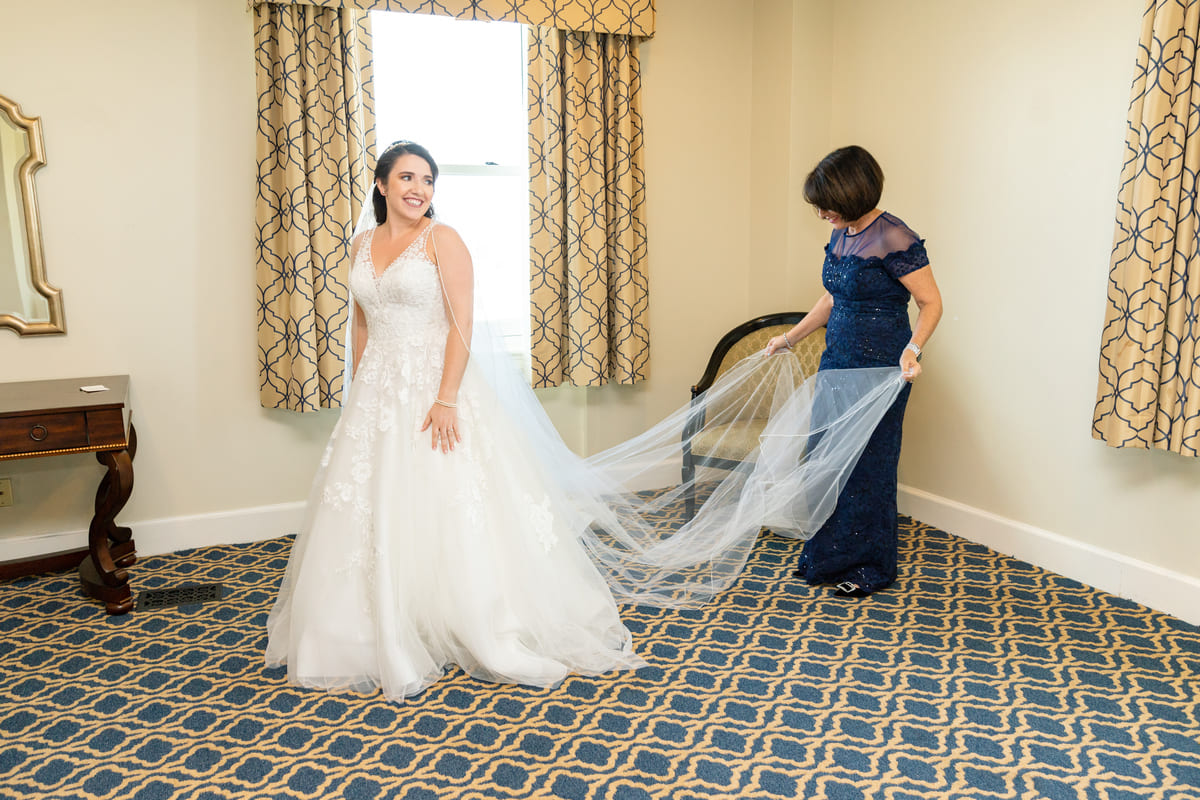 bridesmaids helping bride dress