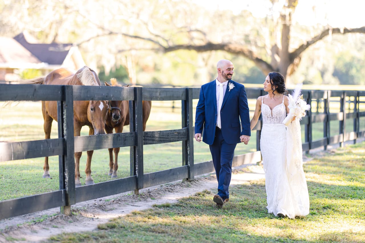 boone hall plantation wedding couple walking near horses