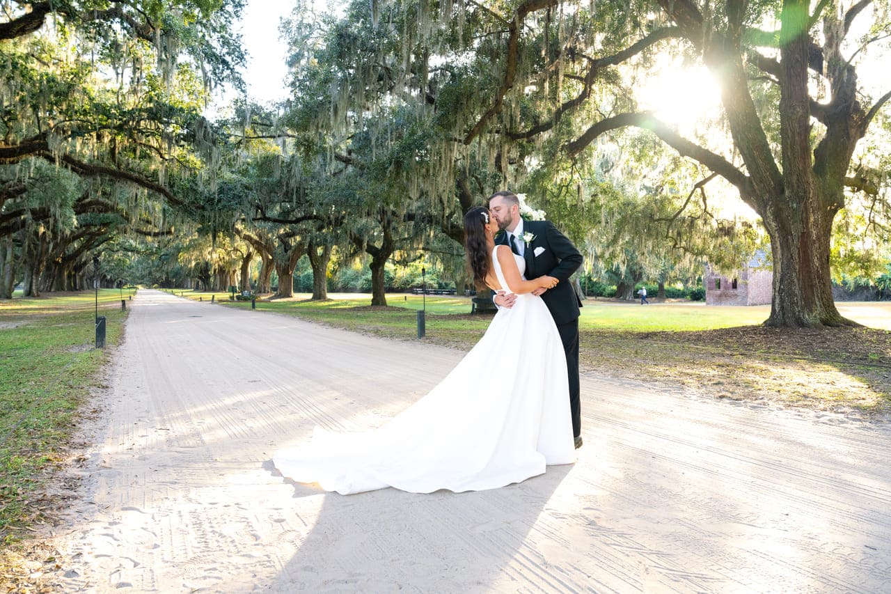 boone hall plantation wedding kissing newlyweds live oaks