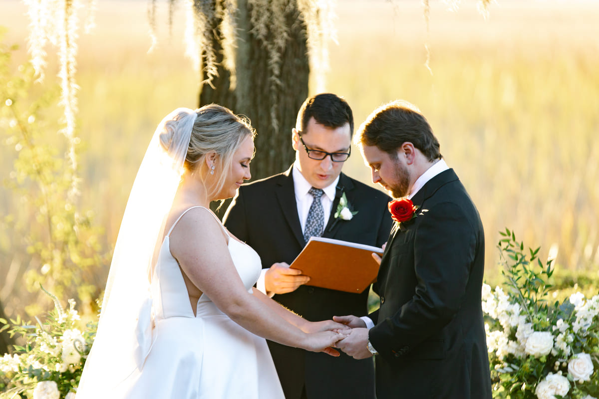 couple and officiant outdoor wedding creek club