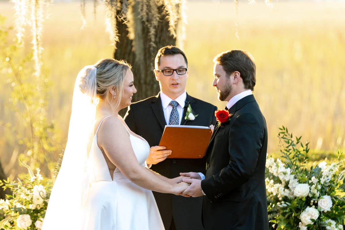 smiling couple wedding ceremony creek club charleston