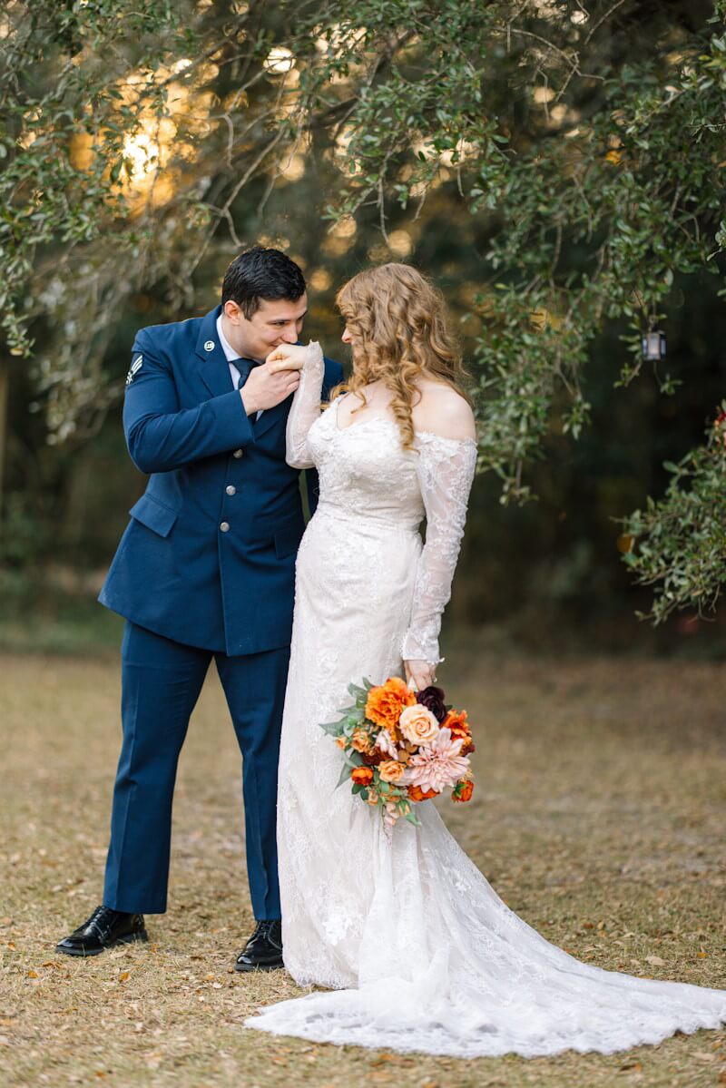 Bride and groom embracing near blooming flowers during intimate elopement