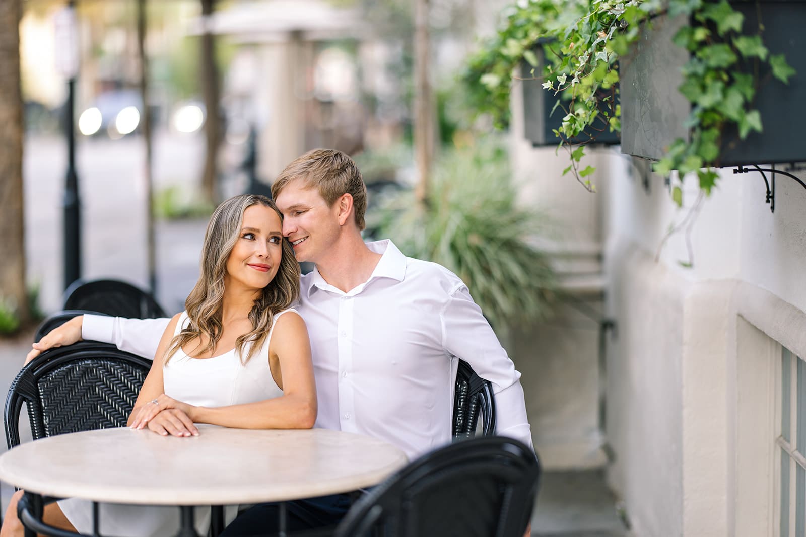 Happy couple sitting together after proposal at a local Charleston cafe